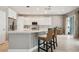 Bright kitchen featuring white cabinetry, stainless steel appliances, and an island with a breakfast bar at 10439 Greendale Dr, Tampa, FL 33626