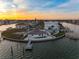 An elevated view of a waterfront home with a pool and private dock on a sunny day at 11005 5Th E St, Treasure Island, FL 33706