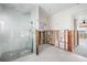 Bathroom featuring a spacious shower with glass door and marble tiling accents and flooring at 11005 5Th E St, Treasure Island, FL 33706