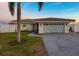 Inviting home featuring a two-car garage, with a well-maintained lawn, in a waterfront community at 11005 5Th E St, Treasure Island, FL 33706