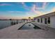 Waterfront home featuring a beautiful pool and dock with stunning sunset views over the water at 11005 5Th E St, Treasure Island, FL 33706