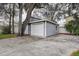 Detached two-car garage with siding and white doors, surrounded by mature trees at 1111 Dr M L King Jr N St, Safety Harbor, FL 34695