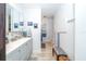 Bathroom with gray vanity, white countertop, framed mirror, and shower with a patterned curtain at 12111 Scott Dr, Dade City, FL 33525