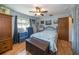 Bedroom with hardwood floors, ceiling fan, a window with curtains, and a comfortable bed at 12111 Scott Dr, Dade City, FL 33525