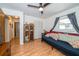 Bedroom showcasing hardwood floors, futon, window with grey curtains, and wardrobe at 12111 Scott Dr, Dade City, FL 33525