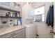 Convenient laundry room with stacked washer and dryer and cabinets for storage at 12111 Scott Dr, Dade City, FL 33525