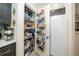 Organized pantry with shelving and door storage, adjacent to a white refrigerator at 12111 Scott Dr, Dade City, FL 33525
