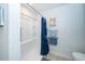 Minimalist shower with white tile, built-in shelving, and a stylish patterned blue shower curtain at 12111 Scott Dr, Dade City, FL 33525