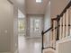 Bright and airy foyer featuring wood-look floors and an elegant staircase with natural light at 12307 Juniper Field Ct, Riverview, FL 33579