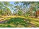 Backyard with a view of the home and an abundance of gorgeous, mature trees at 13450 Wilcox Rd, Largo, FL 33774