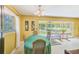 Dining area features a green table cloth and access to a screened back porch at 13450 Wilcox Rd, Largo, FL 33774