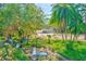 Beautiful house with a well-manicured front yard, mature trees, and a picturesque creek running through the lush green landscape at 13450 Wilcox Rd, Largo, FL 33774