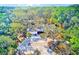 Exterior shot of home surrounded by mature trees and greenery, with a spacious driveway and carport at 13450 Wilcox Rd, Largo, FL 33774