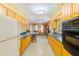 Open kitchen with wood cabinets, laminate countertops and view to living area at 13450 Wilcox Rd, Largo, FL 33774