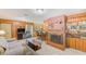 Open living room featuring wood paneling, a brick fireplace, and seamless access to the kitchen area at 13450 Wilcox Rd, Largo, FL 33774