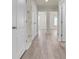 Hallway with laminate flooring and multiple white doors leading to various rooms at 13946 Snapper Fin Ln, Tampa, FL 33637
