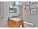 Bathroom with a single sink vanity, toilet, and framed mirror at 15427 Bama Breeze Pl, Wimauma, FL 33598