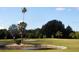 Picturesque golf course with a water hazard, manicured greens, and mature trees, set against a clear blue sky at 1718 Golfview Dr # 1718, Tarpon Springs, FL 34689