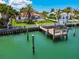 Aerial view of the waterfront house featuring a boat dock, swimming pool and lush landscaping at 205 Harrison Ave, Belleair Beach, FL 33786