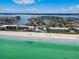 Breathtaking aerial perspective showcasing beachfront homes along a pristine shoreline with turquoise waters at 205 Harrison Ave, Belleair Beach, FL 33786