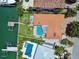 An aerial view shows the property featuring a private pool, outdoor living, and dock on a waterfront property at 205 Harrison Ave, Belleair Beach, FL 33786