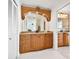 Bathroom vanity featuring a unique wooden arched mirror frame and granite countertop at 205 Harrison Ave, Belleair Beach, FL 33786