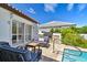 Poolside patio with comfortable seating, grill, and lush landscaping at 205 Harrison Ave, Belleair Beach, FL 33786