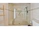 Shower featuring glass doors, bench, neutral tiles, and a modern shower head at 205 Harrison Ave, Belleair Beach, FL 33786