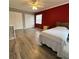 Bright bedroom featuring light floors, red accent wall, ceiling fan and spacious closet at 2233 Greenhaven Dr # 363, Sun City Center, FL 33573