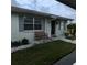 Charming front entrance featuring a cozy bench, well-kept lawn, and decorative stone accents at 2233 Greenhaven Dr # 363, Sun City Center, FL 33573