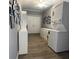 Bright laundry room with washer/dryer, white cabinets, wood floors, and decorative wall art at 2233 Greenhaven Dr # 363, Sun City Center, FL 33573