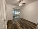 Bedroom with wood-look floors, fan, closet, and sliding glass doors to the lanai at 250 Rosery Nw Rd # 220, Largo, FL 33770