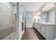 Bathroom with a glass-enclosed shower featuring gray tile and wood-look flooring, as well as a double sink at 2882 Murray Pass, Odessa, FL 33556