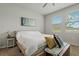 Bedroom featuring a cozy bed, natural light from the windows, and a rustic wooden chest with pillows at 33901 Floating Heart Ct, Wesley Chapel, FL 33545