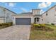 Charming home featuring a two-car garage, paver driveway, and well-maintained landscaping at 33901 Floating Heart Ct, Wesley Chapel, FL 33545