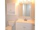 Bathroom featuring a vanity with white cabinets, a framed mirror, and cabinet above toilet at 3399 Mermoor Dr # 110, Palm Harbor, FL 34685