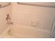 Bathroom featuring a beige bathtub with chrome fixtures, grab bar, and light tile at 3399 Mermoor Dr # 110, Palm Harbor, FL 34685