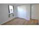Well-lit bedroom featuring wood-look floors, a window with curtains and a double door closet at 3399 Mermoor Dr # 110, Palm Harbor, FL 34685