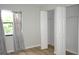 A bedroom featuring wood-look floors, a window, and closet with open doors at 3399 Mermoor Dr # 110, Palm Harbor, FL 34685