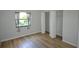 Bedroom featuring light walls, wood-look flooring, a window, and a closet at 3399 Mermoor Dr # 110, Palm Harbor, FL 34685