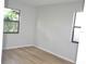 Bright bedroom featuring wood-look floors and two windows providing ample natural light at 3399 Mermoor Dr # 110, Palm Harbor, FL 34685