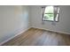 Light bedroom with wood-look floors, window, and neutral walls at 3399 Mermoor Dr # 110, Palm Harbor, FL 34685