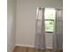 Bedroom featuring wood-look floors and a sunlit window with privacy curtains at 3399 Mermoor Dr # 110, Palm Harbor, FL 34685