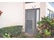 Exterior door surrounded by tropical landscaping and decorative plants at 3399 Mermoor Dr # 110, Palm Harbor, FL 34685