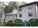 Apartment building exterior with lush, well-maintained landscaping and visible unit number at 3399 Mermoor Dr # 110, Palm Harbor, FL 34685