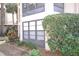 Exterior view of building showing windows and lush landscaping in front at 3399 Mermoor Dr # 110, Palm Harbor, FL 34685