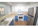 Galley kitchen featuring white cabinets and stainless steel appliances at 3399 Mermoor Dr # 110, Palm Harbor, FL 34685