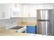 This kitchen is equipped with stainless steel appliances, white cabinets and blue accent cabinets at 3399 Mermoor Dr # 110, Palm Harbor, FL 34685