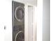 Modern, stacked washer and dryer appliances next to open doorway in laundry area at 3399 Mermoor Dr # 110, Palm Harbor, FL 34685