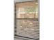 This window has white blinds that look out onto greenery at 3399 Mermoor Dr # 110, Palm Harbor, FL 34685